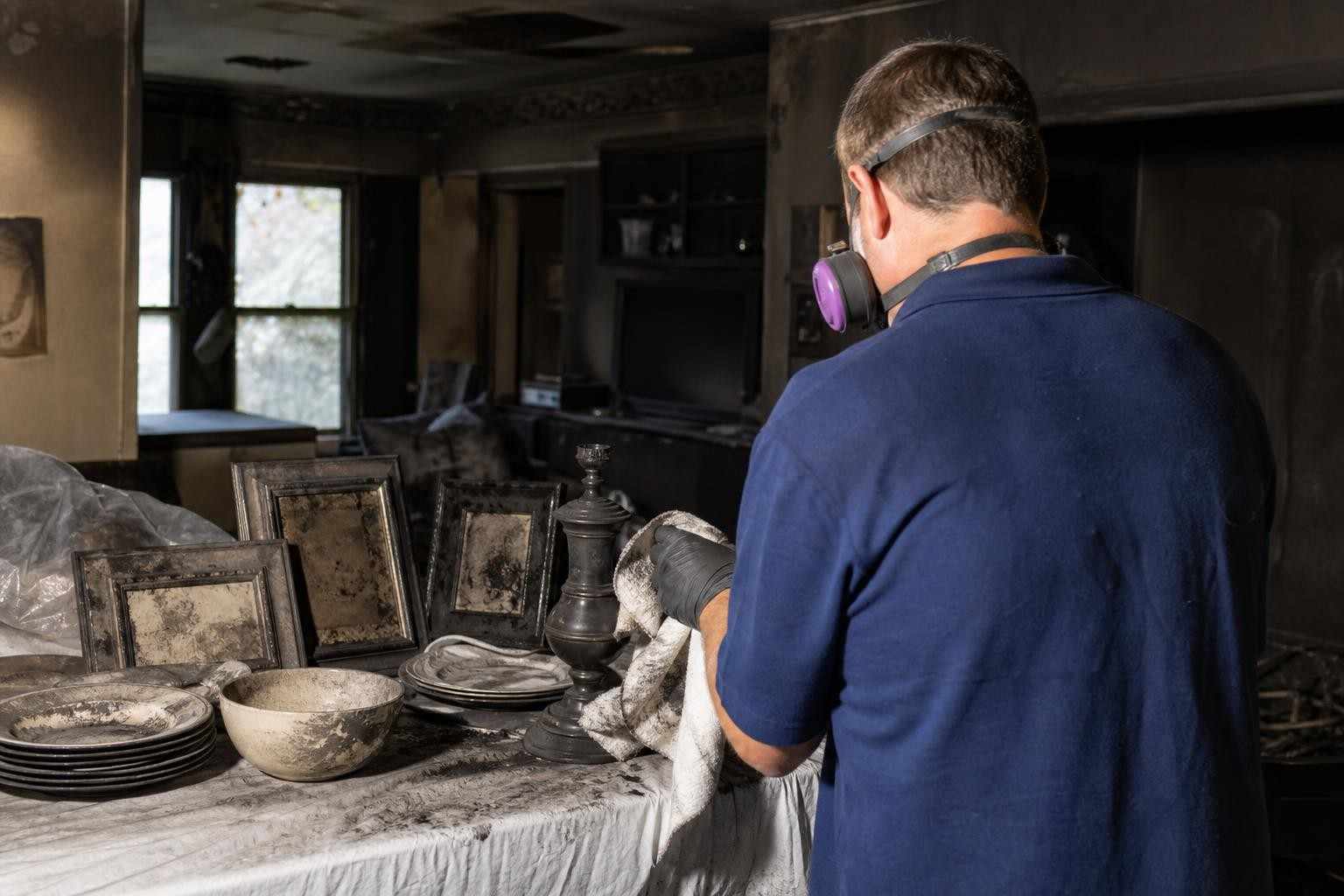Technician cleaning soot from salvageable items after a fire in a Dallas TX home